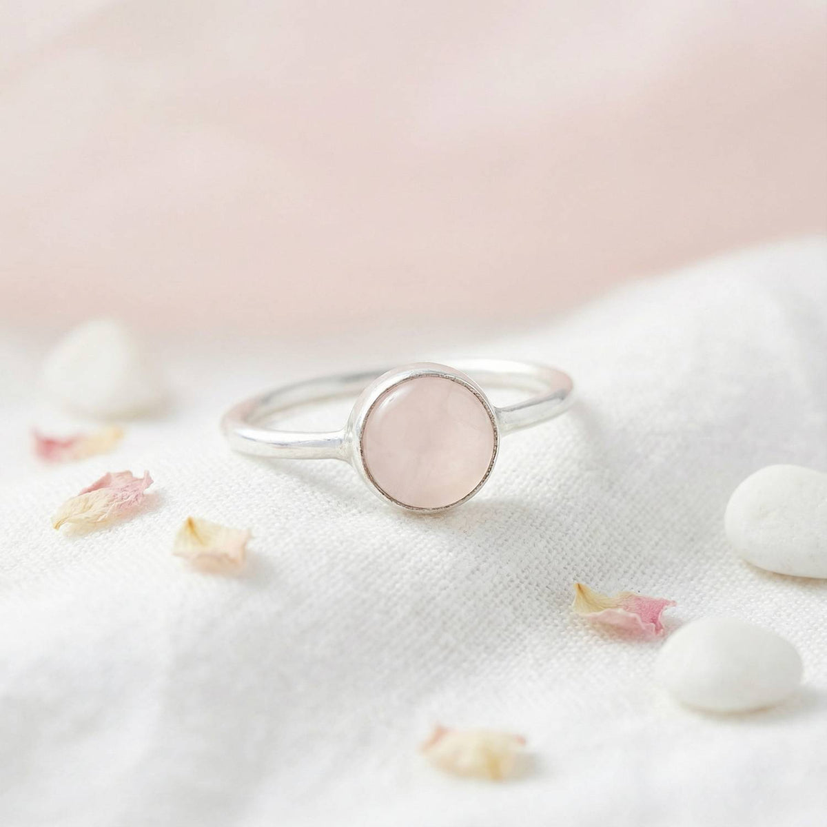 Silberring mit Rosenquarz auf hellem Stoff