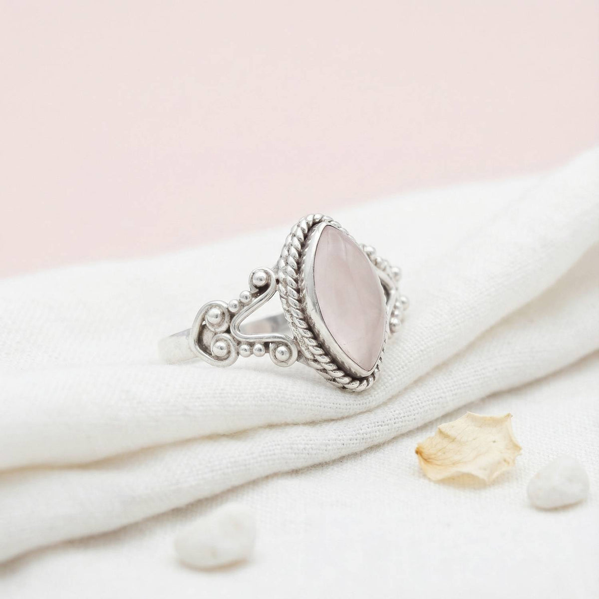 Silberring mit Rosenquarz auf hellem Stoff