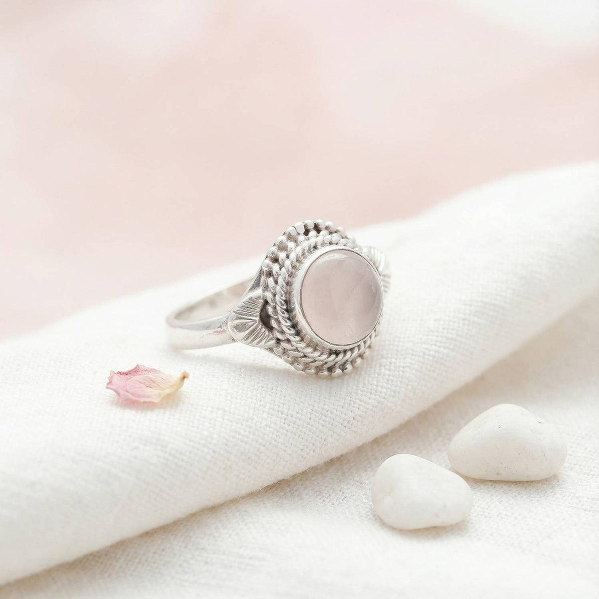 Silberring mit Rosenquarz auf hellem Stoff