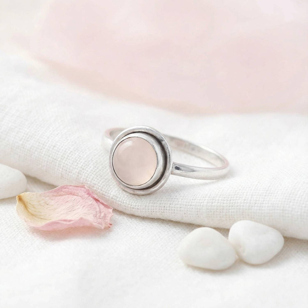 Silberring mit Rosenquarz auf hellem Stoff