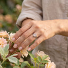 [KI] Silberring mit Rosenquarz an der Hand zwischen Blumen