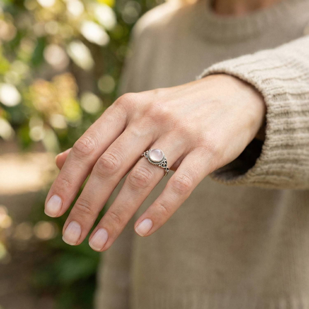 Rosenquarzring aus Silber getragen an der Hand im Freien