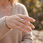 [KI] Rosenquarzring aus Silber getragen an der Hand im Freien