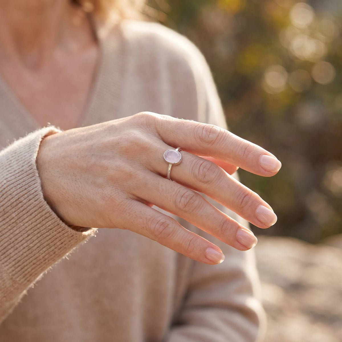 Rosenquarzring aus Silber getragen an der Hand im Freien