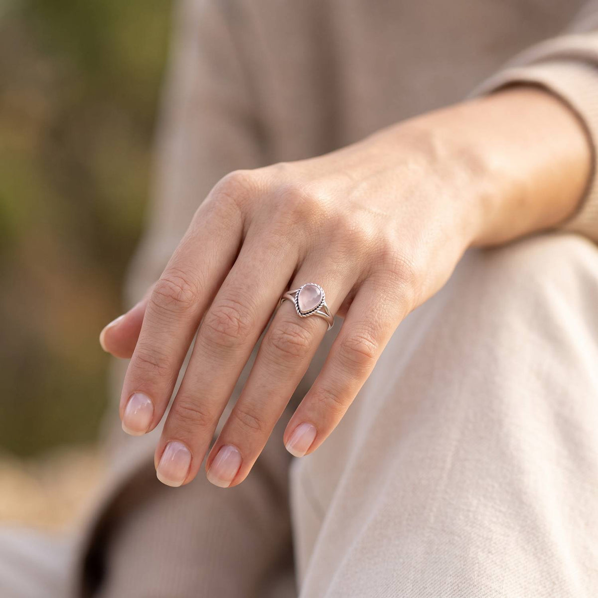 Rosenquarzring aus Silber getragen an der Hand im Freien