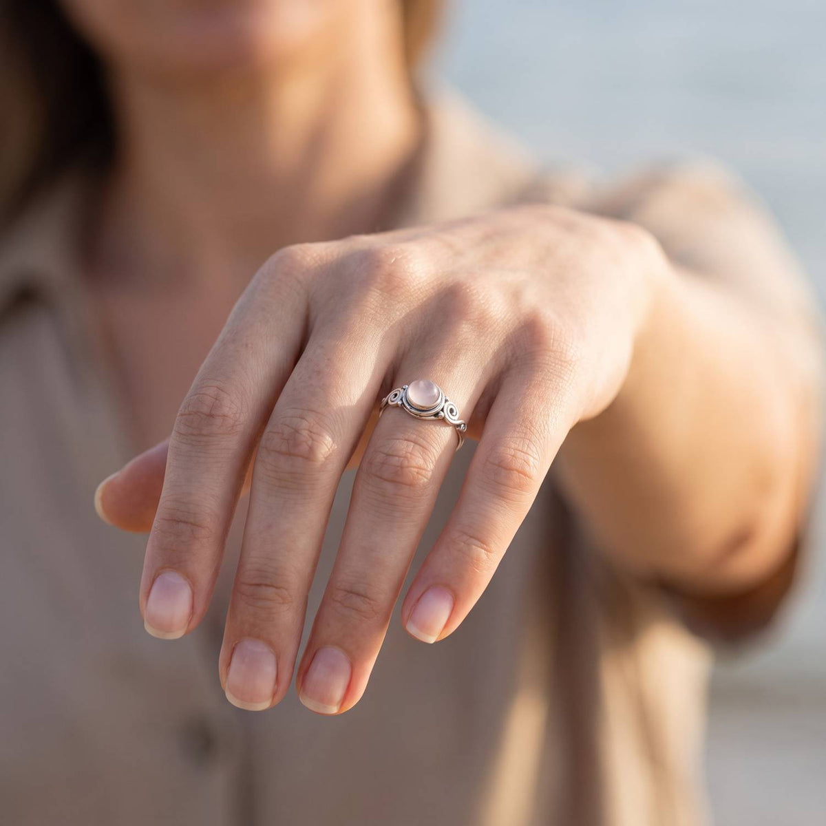 Rosenquarzring aus Silber getragen an der Hand im Freien