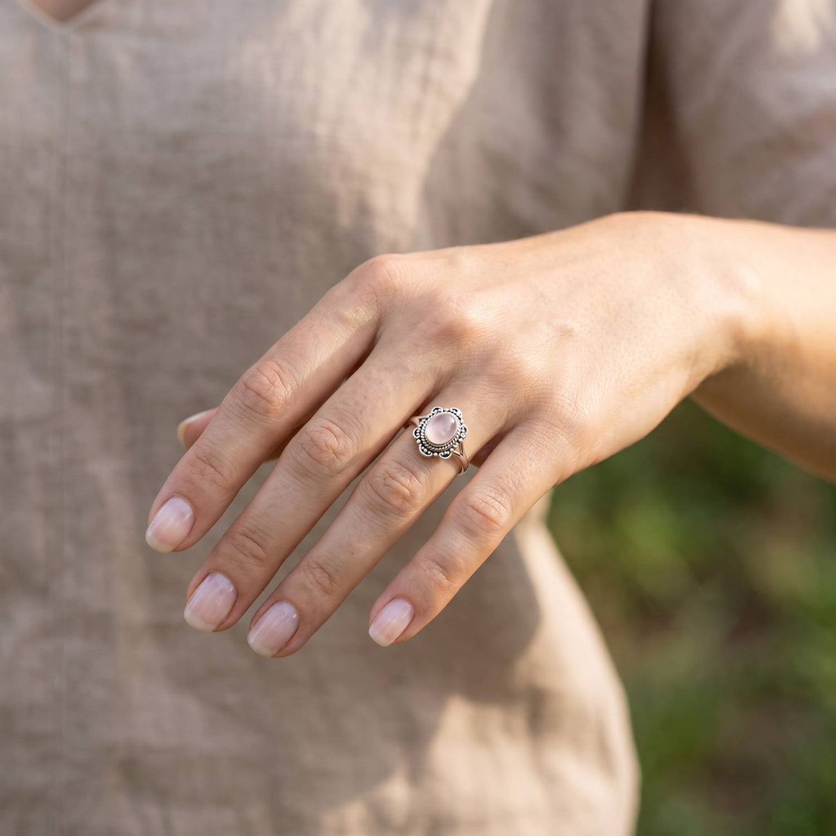 Rosenquarzring aus Silber getragen an der Hand im Freien