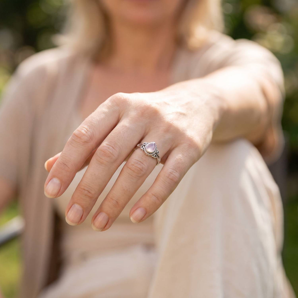 Rosenquarzring aus Silber getragen an der Hand im Freien
