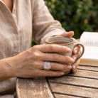 [KI] Rosenquarzring aus Silber getragen beim Lesen mit einer Tasse