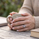 [KI] Rosenquarzring aus Silber getragen beim Lesen mit einer Tasse
