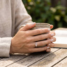 [KI] Rosenquarzring aus Silber getragen beim Lesen mit einer Tasse
