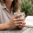 [KI] Rosenquarzring aus Silber getragen beim Lesen mit einer Tasse
