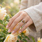 [KI] Silberring mit Tigerauge an der Hand zwischen Blumen