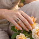 [KI] Silberring mit Tigerauge an der Hand zwischen Blumen