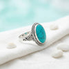 [KI] Silberring mit Türkis auf hellem Stoff