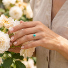 [KI] Silberring mit Türkis an der Hand zwischen Blumen