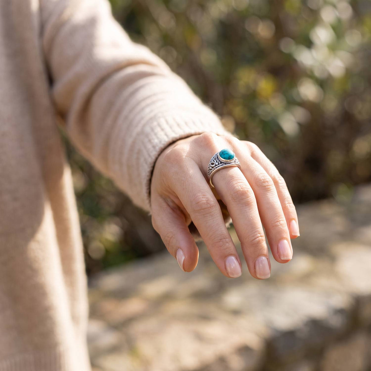 Türkisring aus Silber getragen an der Hand im Freien