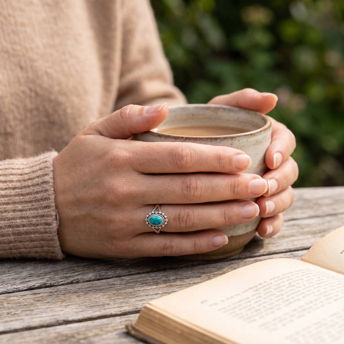 Türkisring aus Silber getragen beim Lesen mit einer Tasse