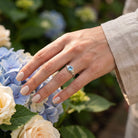 [KI] Silberring mit Topas an der Hand zwischen Blumen
