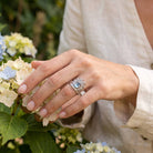 [KI] Silberring mit Topas an der Hand zwischen Blumen