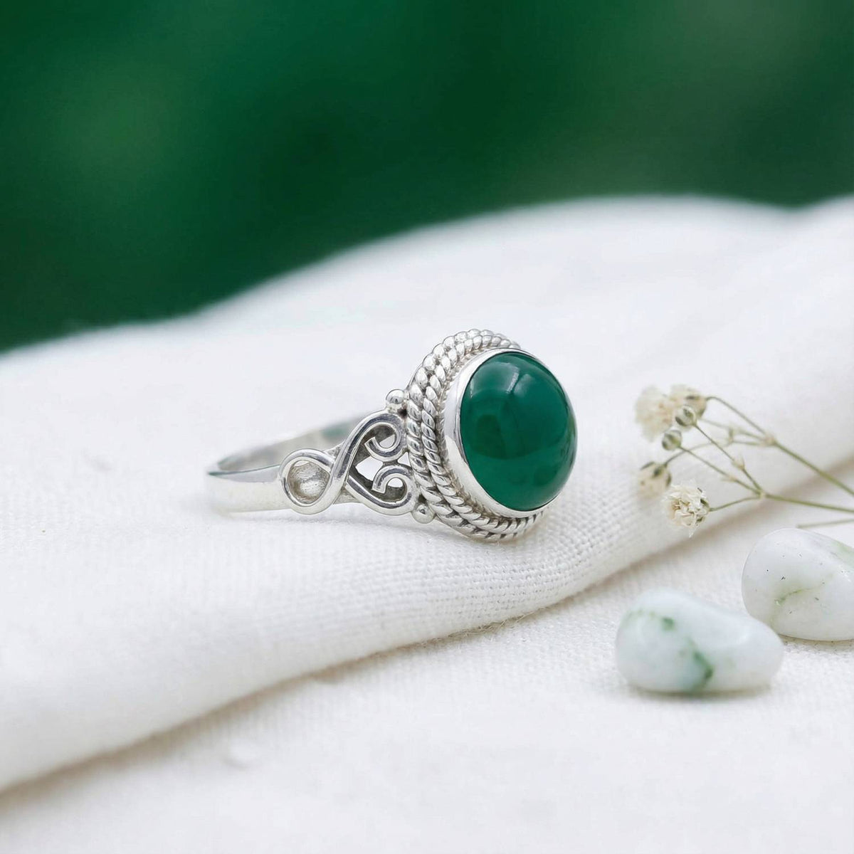 Silberring mit grüner Onyx auf hellem Stoff