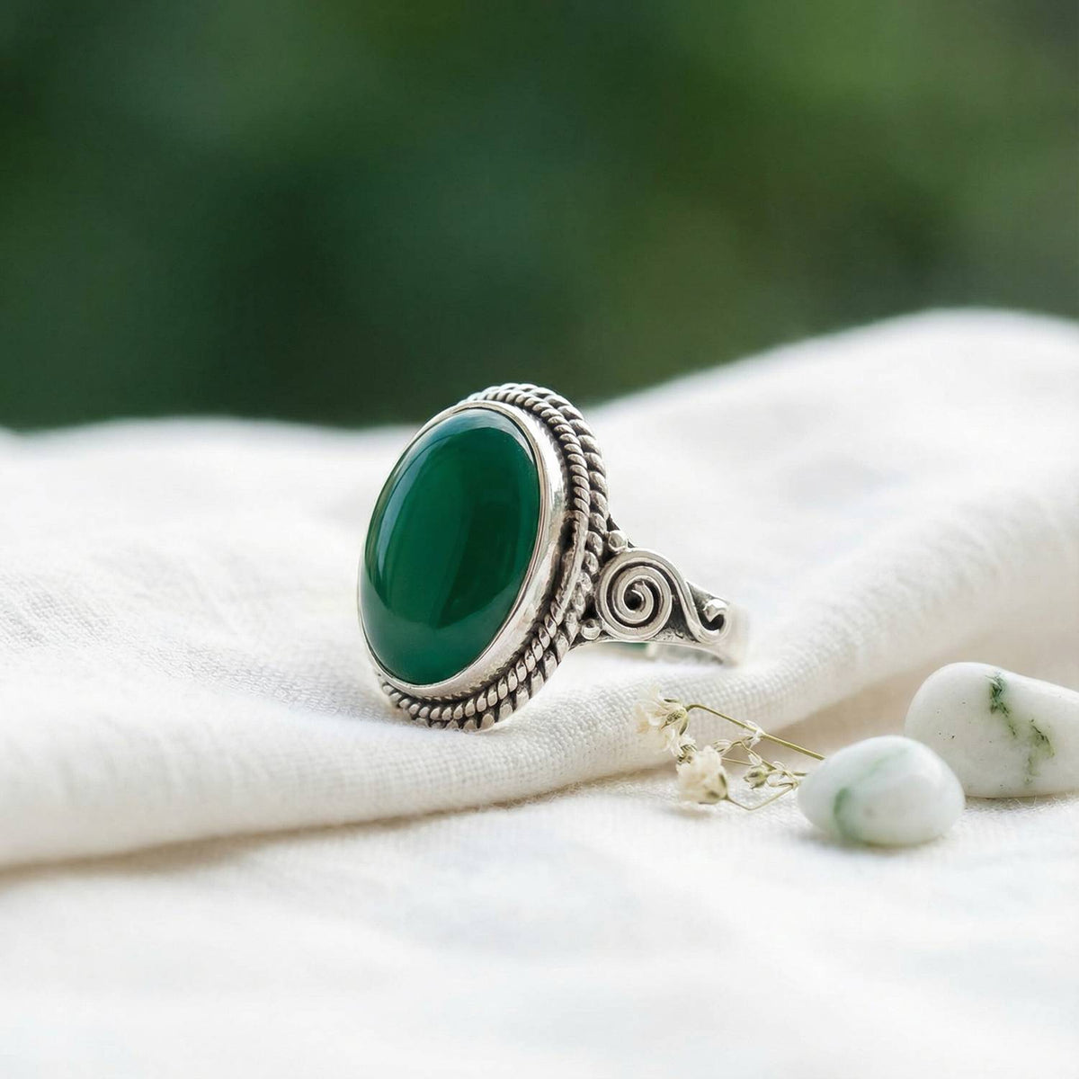 Silberring mit grüner Onyx auf hellem Stoff
