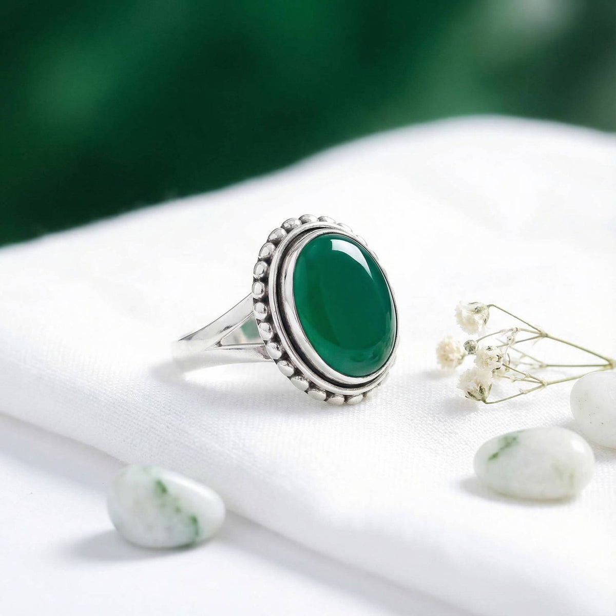 Silberring mit grüner Onyx auf hellem Stoff