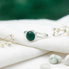 [KI] Silberring mit grüner Onyx auf hellem Stoff