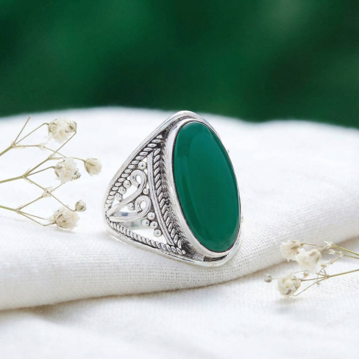 Silberring mit grüner Onyx auf hellem Stoff