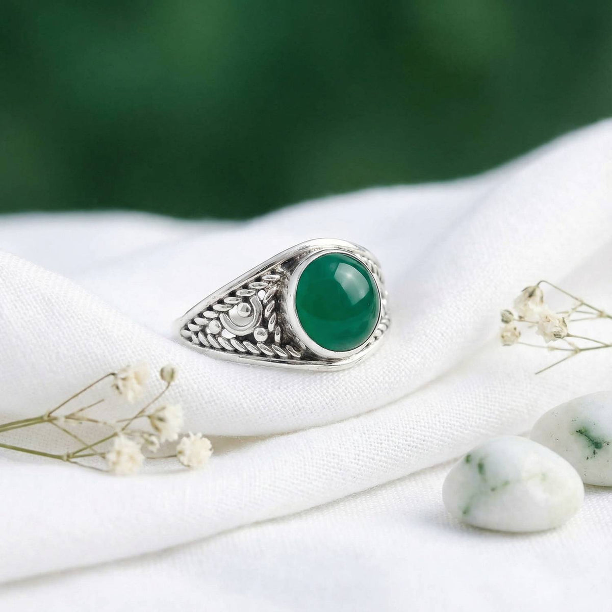 Silberring mit grüner Onyx auf hellem Stoff
