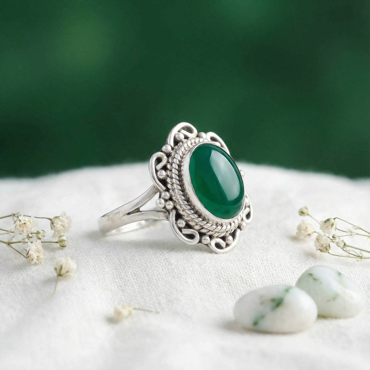 Silberring mit grüner Onyx auf hellem Stoff