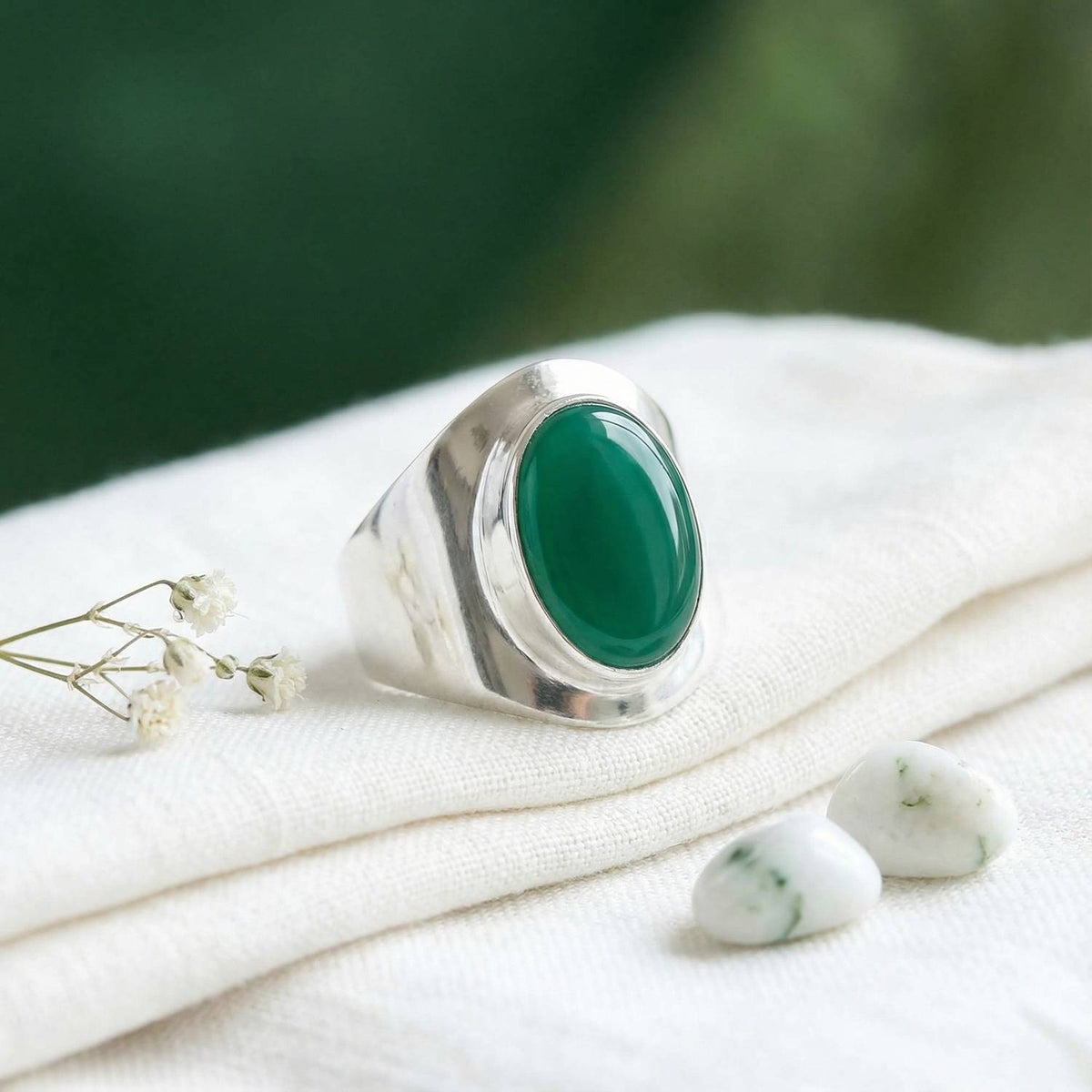 Silberring mit grüner Onyx auf hellem Stoff