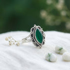 [KI] Silberring mit grüner Onyx auf hellem Stoff
