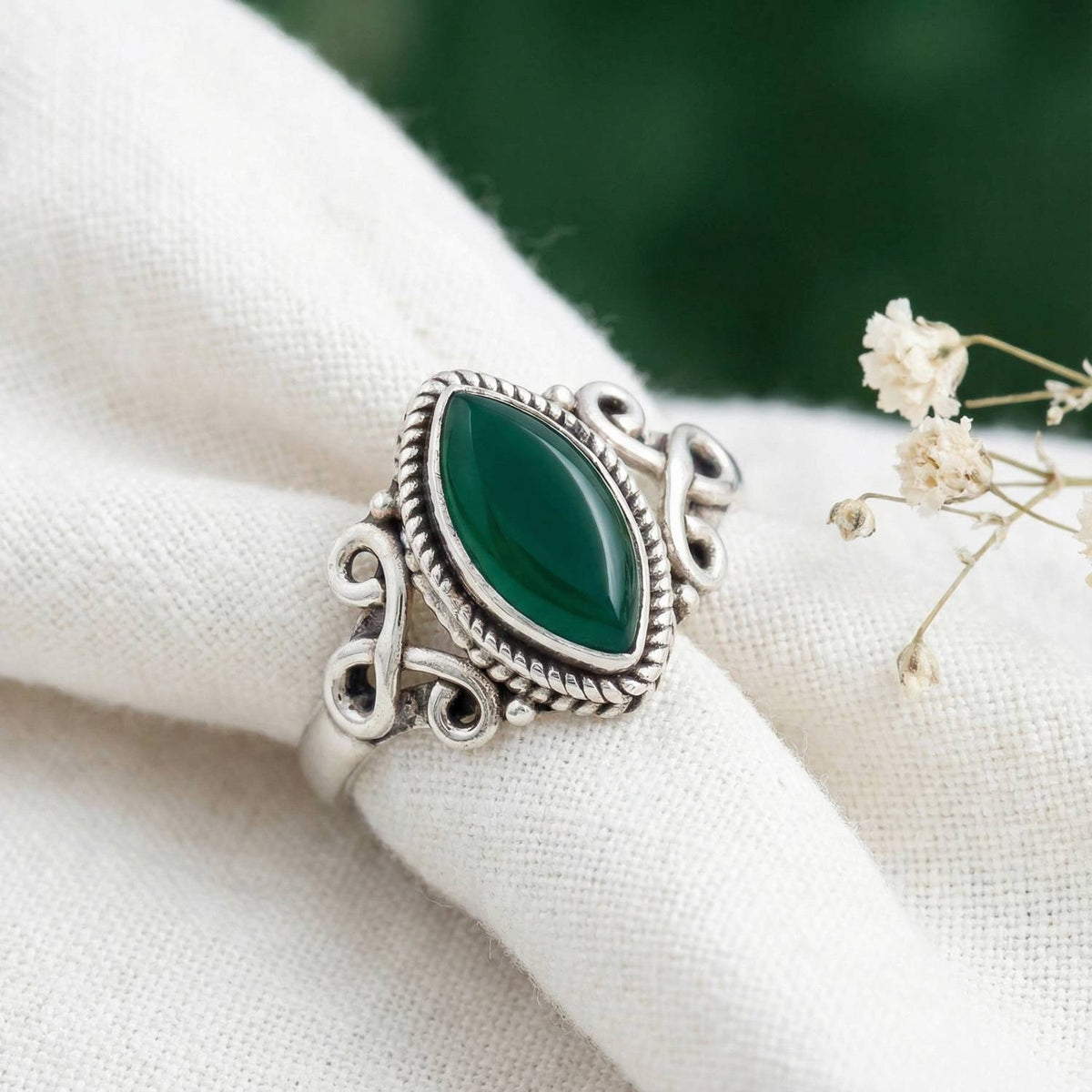 Silberring mit grüner Onyx auf hellem Stoff