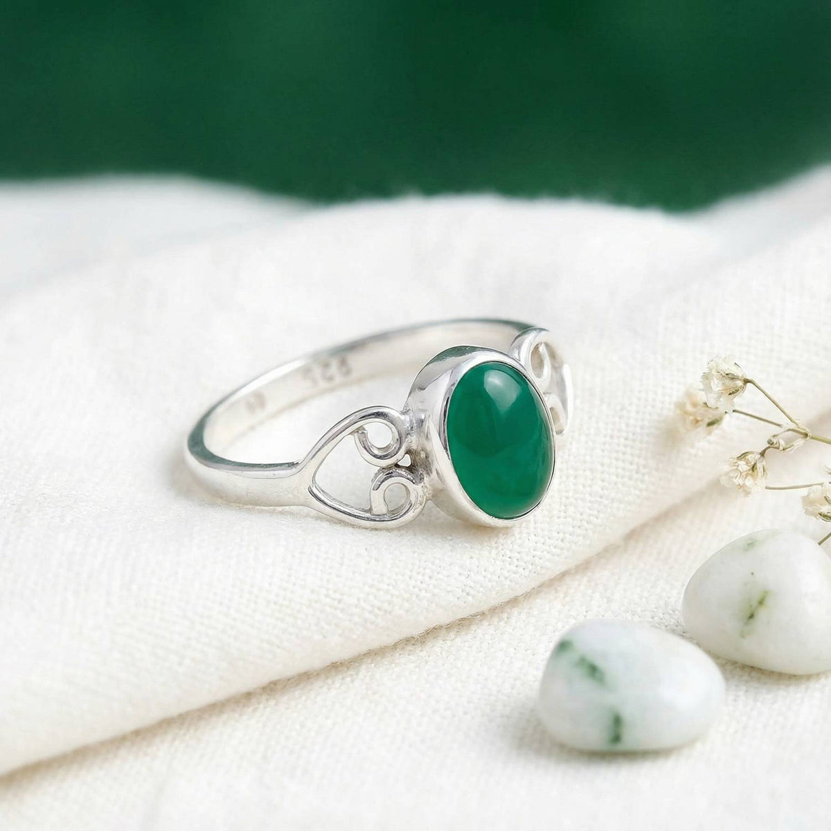 Silberring mit grüner Onyx auf hellem Stoff