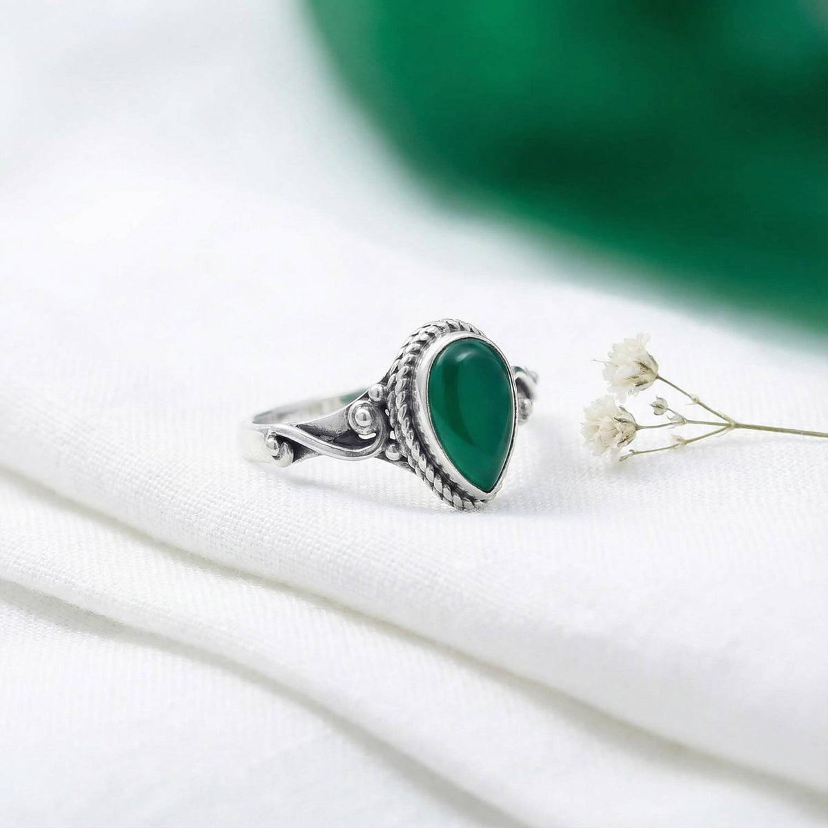 Silberring mit grüner Onyx auf hellem Stoff
