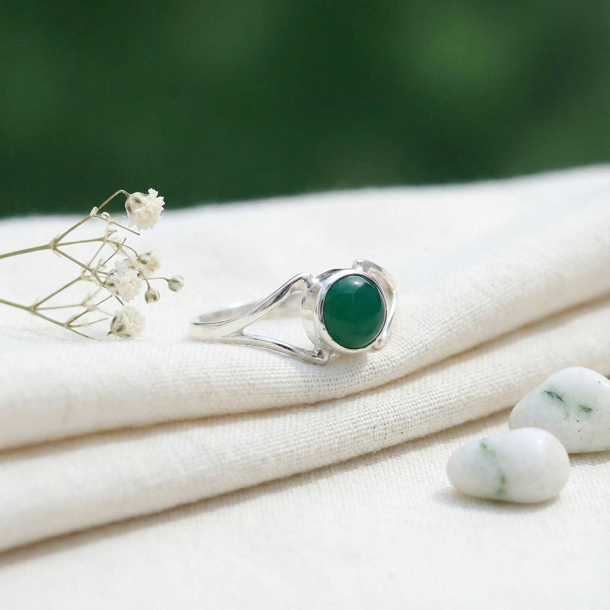 Silberring mit grüner Onyx auf hellem Stoff