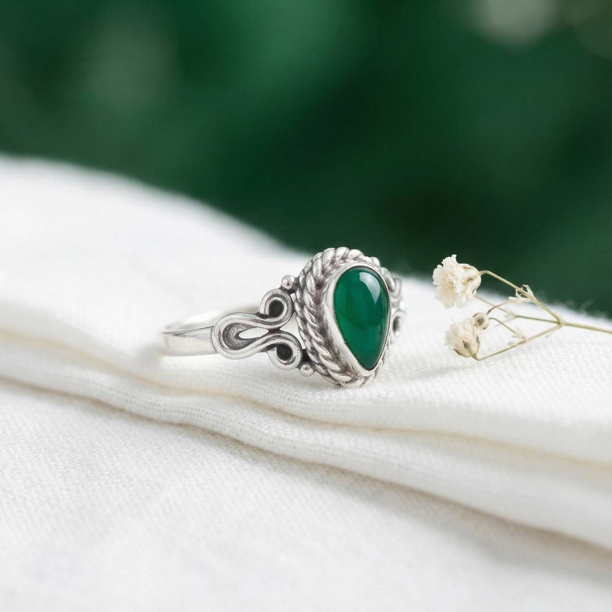 Silberring mit grüner Onyx auf hellem Stoff