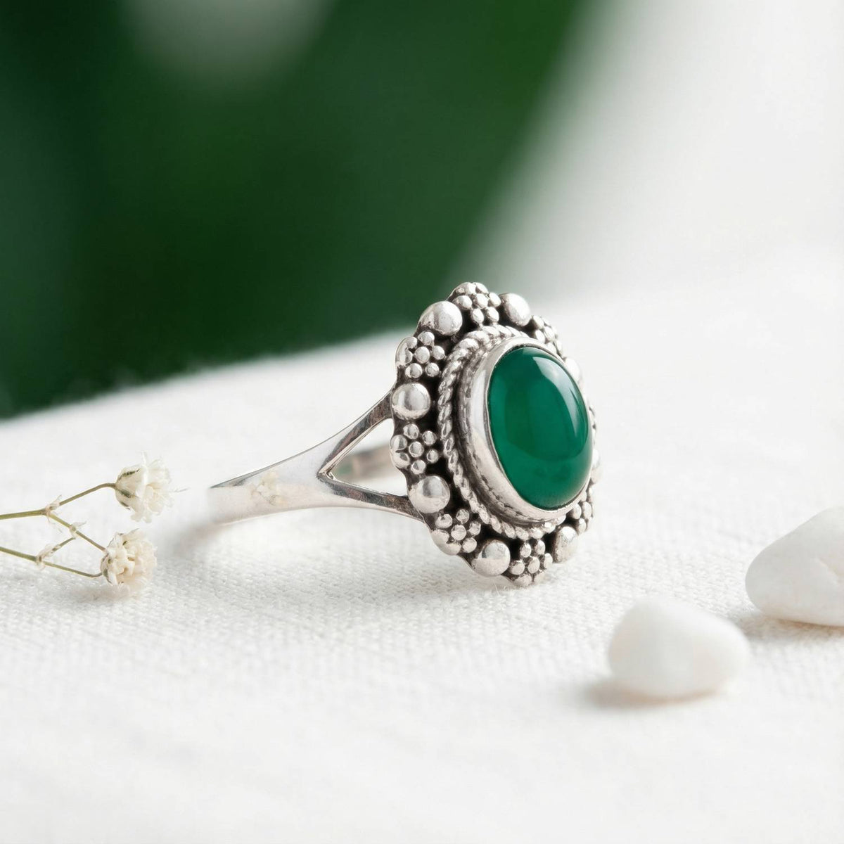 Silberring mit grüner Onyx auf hellem Stoff