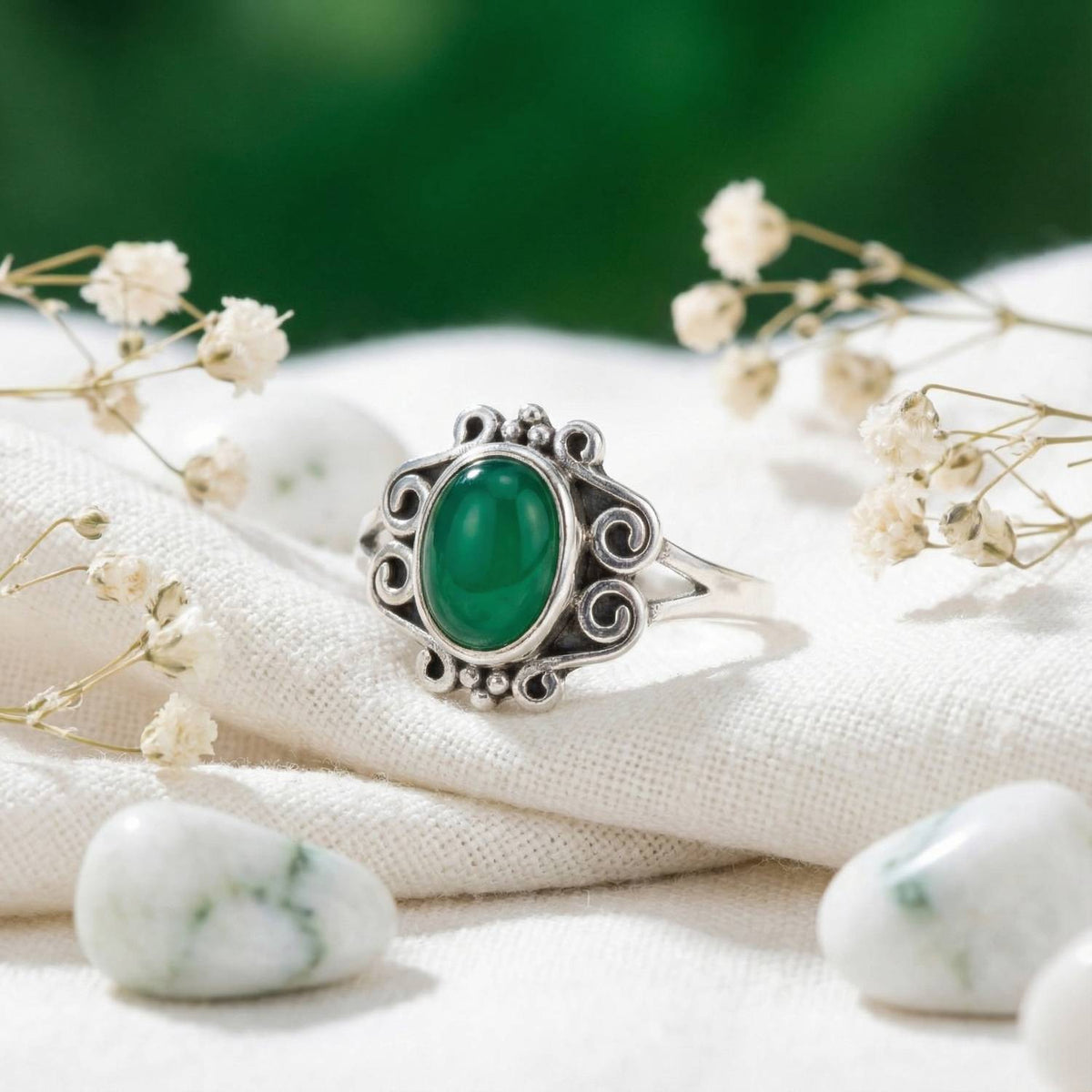 Silberring mit grüner Onyx auf hellem Stoff