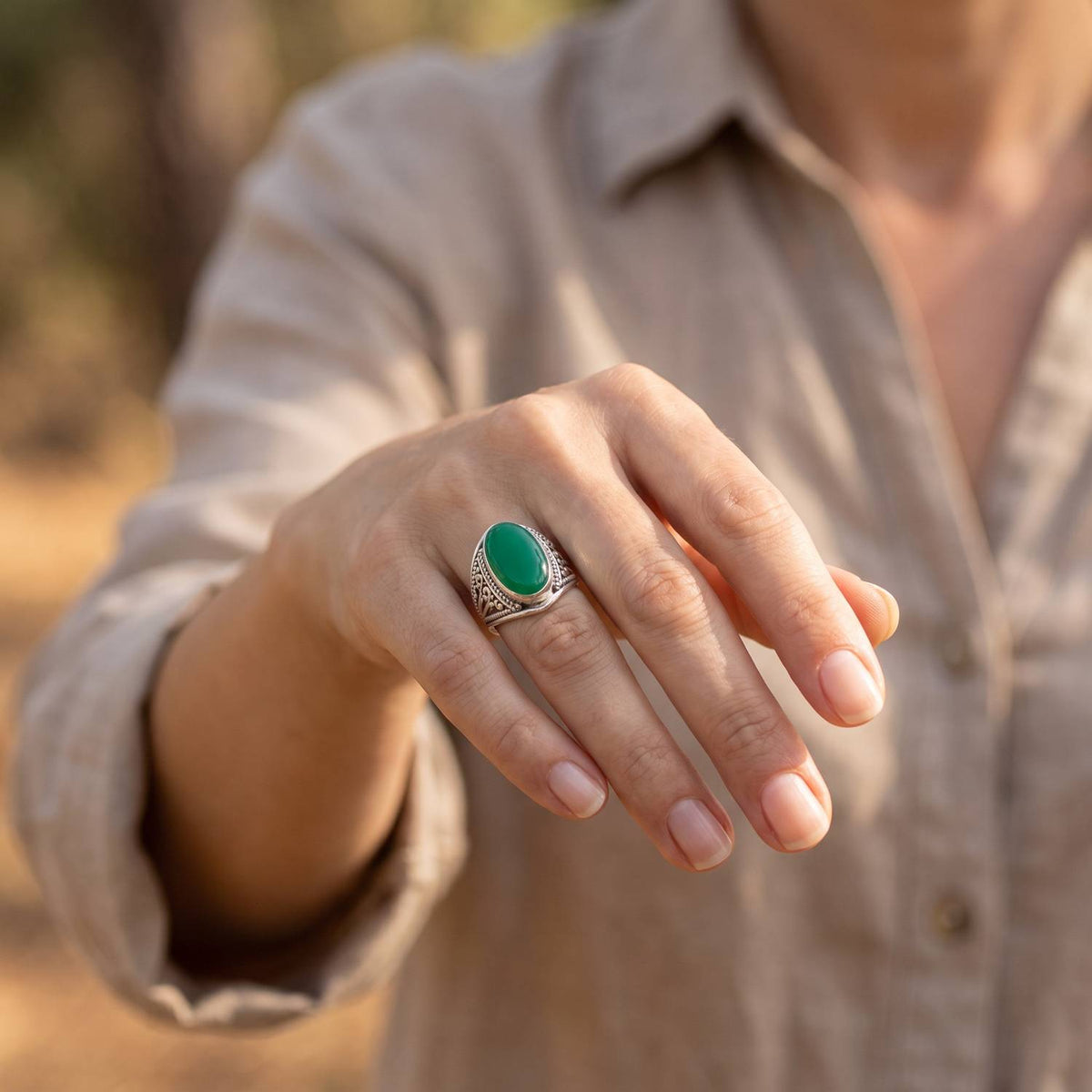 grüner Onyxring aus Silber getragen an der Hand im Freien