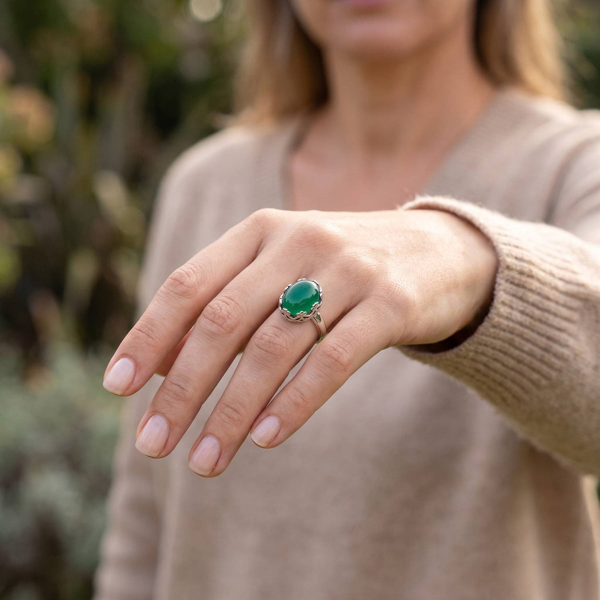 grüner Onyxring aus Silber getragen an der Hand im Freien