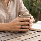 [KI] Karneolring aus Silber getragen beim Lesen mit einer Tasse