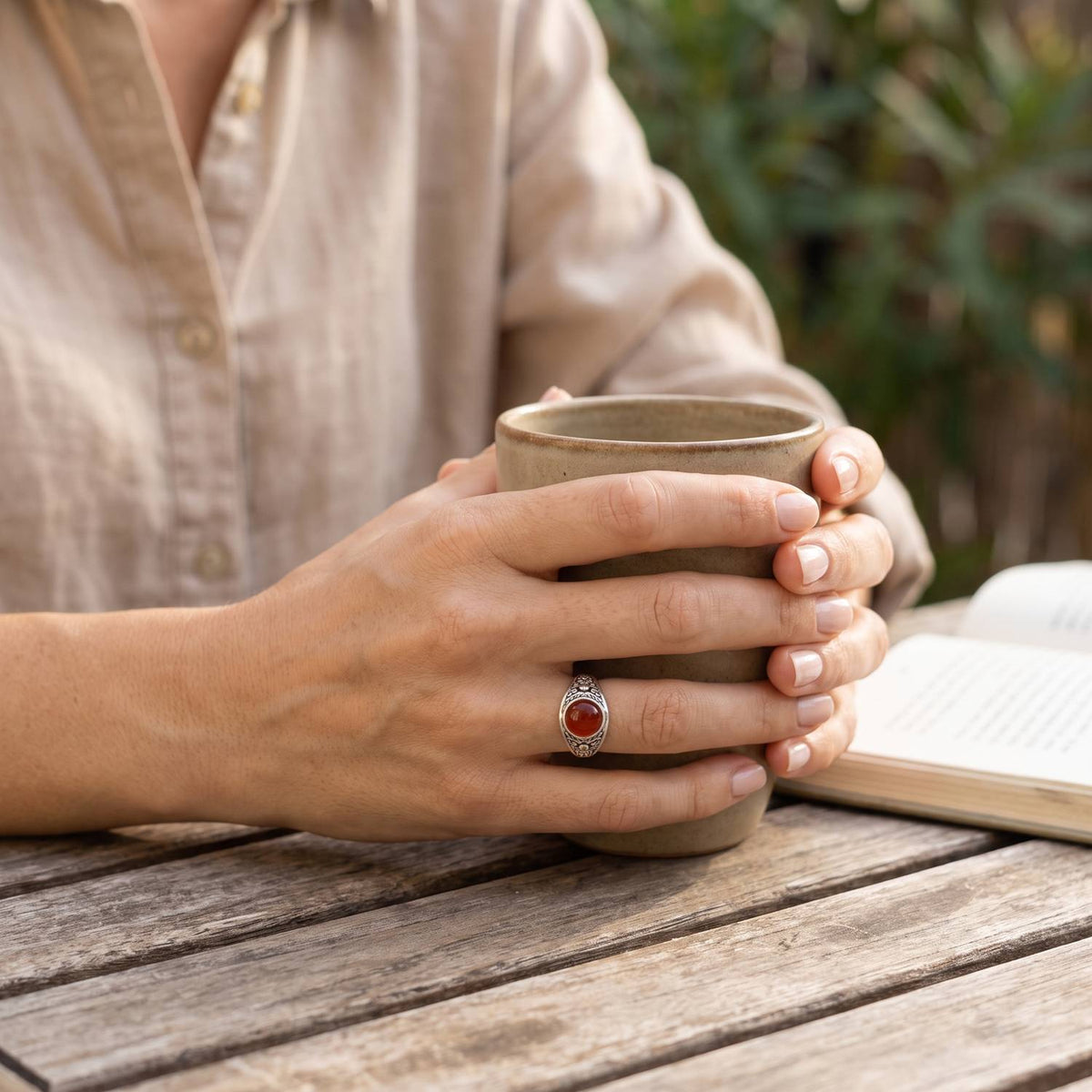 Karneolring aus Silber getragen beim Lesen mit einer Tasse